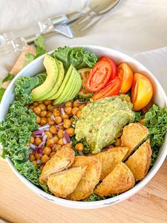 a salad with avocado, tomatoes, lettuce and chickpeas