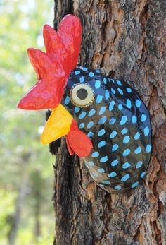 a colorful bird head on the side of a tree