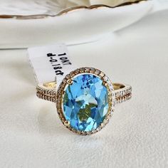 a ring with a blue topaz surrounded by white and yellow diamonds on a table