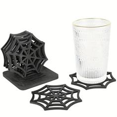 two spider web coasters and a glass on a white background, one is black