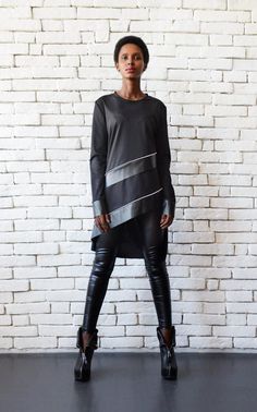 Leather stripes tunic top - METT0088 The ultimate urban style tunic top with an accent black leather stripes - the perfect gift for every fashionista. It is not only beautiful, modern and fashionable, but very comfortable to wear due to the loose and oversize shape it has. This great tunic top looks wonderful with tight black leggings and some high heeled boots. This black blouse is made of cotton and eco leather. SUBSCRIBE TO OUR NEWSLETTER AND RECEIVE 15% DISCOUNT FOR YOUR ORDER! DON'T MISS AN Leather Tunic, Dress Over Pants, Bronze Hair, Tracksuit Outfit, Loose Tunic, Leather Detail, Black Tunic, Stripe Top, Leather Shirt