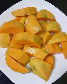 cut up pieces of mango on a white plate