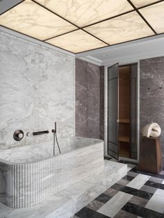 an elegant bathroom with marble walls and flooring, along with a black and white checkered tile floor