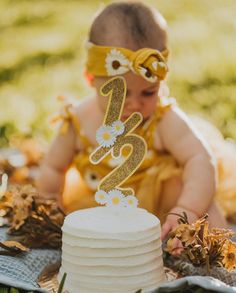 a baby is sitting in front of a cake with the number twenty five on it