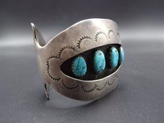 "VINTAGE NAVAJO BRACELET DESCRIPTION: This old cuff features 4 specimens of light blue turquoise, displayed in a hand stamped shadowbox setting. Don't overlook the stamp work on the flared terminals. This bracelet will be a cherished addition to your collection of fine vintage Native American jewelry. MEASUREMENTS: Interior of the cuff measures 5 1/2\" with an additional 1 1/4\" slightly adjustable gap. Total circumference: 6 3/4\" Measures 2 1/2\" straight across the widest part of the cuff (fr Turquoise Stamped Cuff Bracelet Collectible, Vintage Stamped Blue Jewelry, Blue Vintage Stamped Jewelry, Vintage Turquoise Stamped Cuff Bracelet, Artisan Blue Stamped Bracelets, Stamped Turquoise Cuff Bracelet Gift, Turquoise Stamped Cuff Bracelet As Gift, Gift Turquoise Stamped Cuff Bracelet, Blue Stamped Bracelet As Gift