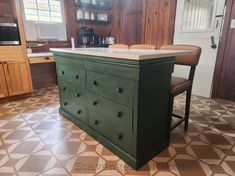 a kitchen with an island in the middle of it and lots of cabinets on both sides