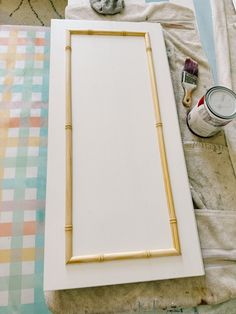 a painting is being made with bamboo and white paint on the table next to it