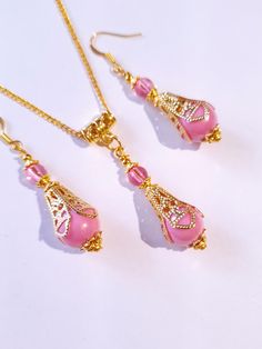 Pink pearl Gold Victorian jewelry set filigree gold set necklace and earrings Boho pink pearl jewelry set Antique style set Gift set Beautiful Set of gold tone filigree ornaments and rose pink acrylic plastic pearls beads and pink little plastic beads pendant necklace and  earrings . Antique style filigree gold tone set necklace and earrings . Gold tone plastic pearls beads Victorian style necklace and earrings . Boho necklace . Boho jewelry set . Boho earrings . Bohemian necklace and earrings . Formal Pink Necklaces With Matching Earrings, Yellow Gold Filigree Jewelry Sets For Gift, Yellow Gold Filigree Jewelry Sets As Gift, Feminine Pink Jewelry With Pearl Drop, Feminine Pink Pearl Drop Jewelry, Feminine Pink Pendant Jewelry, Elegant Pink Necklace With Intricate Design, Pink Jewelry Sets With Matching Earrings As Gift, Elegant Pink Dangle Necklaces