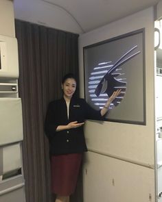 a woman standing in front of an airplane window