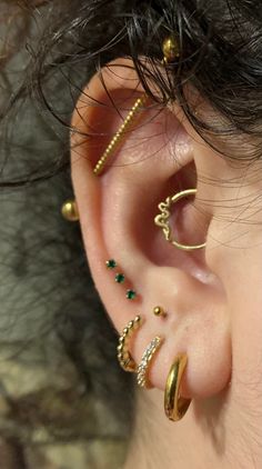 a woman with three different types of ear piercings on her left side of the ear