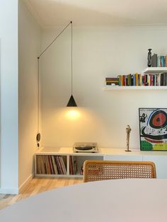 a white room with bookshelves and various items on the shelves, including a record player