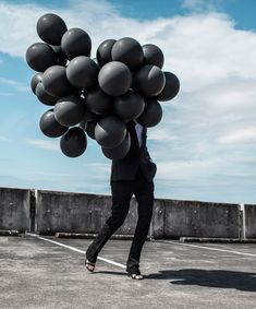 a woman is holding some balloons in her hand