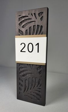 a black and white plaque with the number 2011 on it's side, in front of a gray background