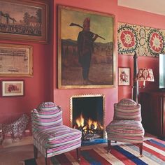 a living room with two chairs and a fire place in the middle of the room