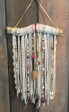 a wall hanging made out of different types of beads and chains on a wooden door