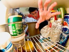 a person reaching for food in an open refrigerator