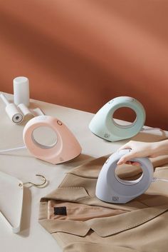 a woman is ironing clothes with an iron on the table next to some sewing supplies