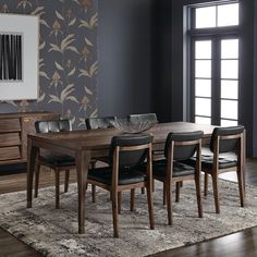 a dining room table with chairs and a rug on the floor in front of it