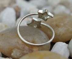 This is the perfect option for those who like cool, unique jewelry and the luxury, shine of silver, clear. This ring is well made, cute and/or elegant in design, and very desirable. The size of the ring is adjustable. It is about 5-6. This ring has an open design with the starts at each end. Each star is decorated with CZ. See photos. ♥Circa before the 2002s. ♥ There is a hallmark. 925. Everyone interested in the jewelry should remember that he or she must like their jewelry- not just at first s Nickel-free Sterling Silver Star Ring, Star-shaped 925 Sterling Silver Rings For Gifts, Star-shaped Stamped 925 Silver Ring As Gift, Star Charm Ring Jewelry Gift, Minimalist Nickel-free Star-shaped Jewelry, Minimalist Nickel-free Star Shaped Jewelry, Minimalist Nickel-free Star Jewelry, Minimalist Star-shaped Nickel-free Jewelry, Star Shaped Stamped 925 Silver Jewelry Gift