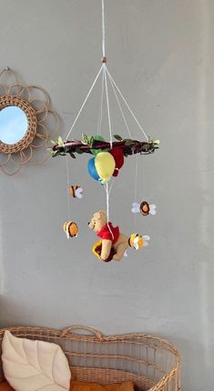 a teddy bear mobile hanging from the ceiling next to a crib with stuffed animals on it