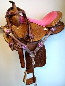 a brown and pink horse saddle hanging on the wall