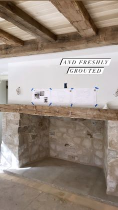 an empty room with stone fireplace and exposed beams