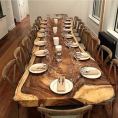 a long wooden table set with place settings for six people to sit down and eat