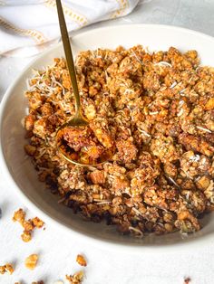 a white bowl filled with granola on top of a table