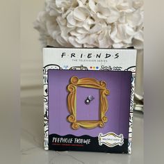 there is a purple box with a mirror on it and a flower in the background