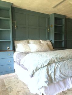 a large bed sitting in the middle of a bedroom next to blue bookcases