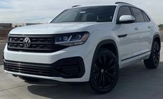 a white volkswagen suv parked in front of a building