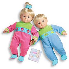 two dolls are laying next to each other