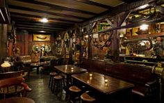 the interior of a bar with wooden tables and stools