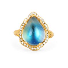 a gold ring with a blue tear shaped stone in the center and diamonds around it