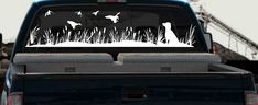 a truck is parked in the grass with birds on it's tail end and back window