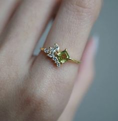 a woman's hand with a yellow and white diamond ring on top of her finger