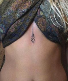 a woman's stomach with a tattoo on her side and an arrow in the middle