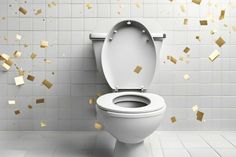 a white toilet sitting next to a tiled wall with gold confetti on it