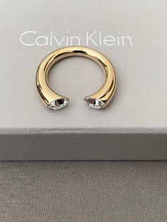 Calvin Klein Brilliant This Calvin Klein ring is very gorgeous on the fingers.    The clear stone makes it stand out. Calvin Klein embossed on the ring. Open ended ring  Comes with box and pouch. Modern Open Ring Jewelry With Vs Clarity, Modern Open Ring With Vs Clarity, Amethyst Open Ring For Anniversary, Modern Crystal Open Ring With Vs Clarity, Luxury Crystal Open Ring, Modern Crystal Open Ring For Anniversary, Modern Open Crystal Ring For Anniversary, Luxury Open Crystal Ring, Vvs Clarity Open Diamond Ring