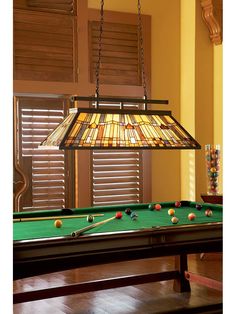 a pool table with a lamp hanging over it