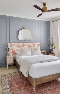 a bedroom with a bed, dresser and ceiling fan in the corner next to a window