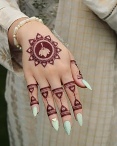 a woman's hand with henna tattoos on it