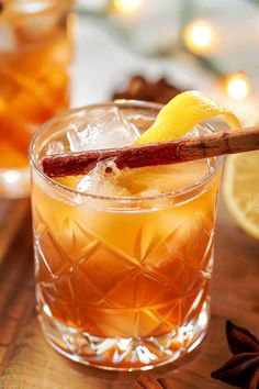 a close up of a drink in a glass with an orange slice on the rim