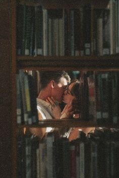 a man is reading in front of a bookshelf