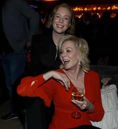 two women sitting next to each other at a party