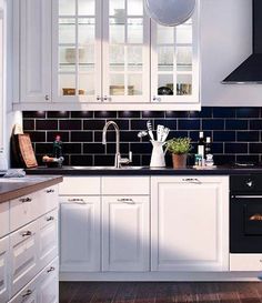 a kitchen with white cabinets and black counter tops is seen in this image from the front view