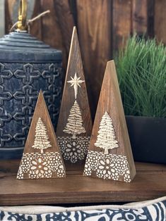 three wooden christmas trees sitting on top of a table