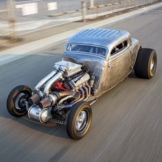 an antique hot rod car driving down the road