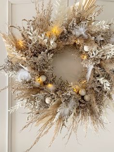 a wreath with lights and feathers on it