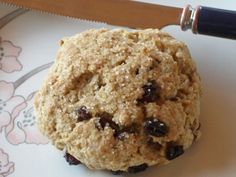 an oatmeal cookie sitting on top of a plate next to a knife